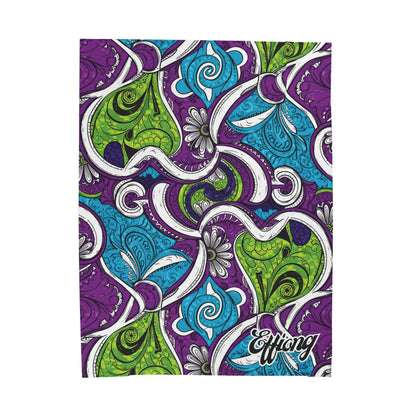A vibrant, abstract, African-inspired blanket pattern featuring swirling shapes and paisleys in green, blue, and purple. Floral and filigree details fill the design. “Effiong” is written in script on this personalized velveteen blanket.