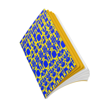 A hardcover African-inspired journal lies open at an angle. Its cover features an ornate blue and gold abstract floral pattern, with yellow-lined edges and partially visible white pages. The background is plain white.