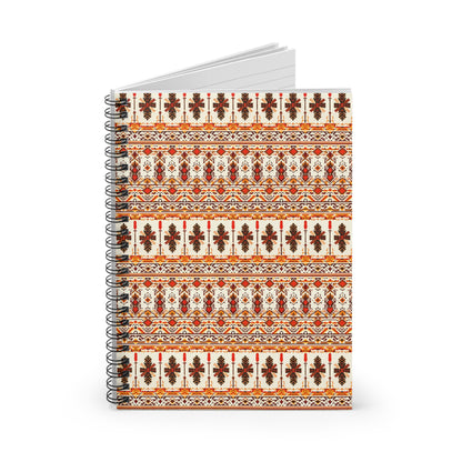 A spiral-bound notebook with a cover featuring intricate, culturally inspired designs in red, orange, and dark brown, including floral and geometric patterns. The notebook is partially open to lined white pages. The background is white.