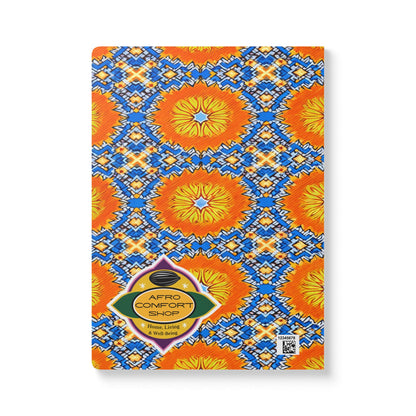 A rectangular African-inspired journal with a vibrant cover featuring orange and yellow circular patterns, blue geometric shapes, and white accents. Perfect for daily journaling, it features the Afro Comfort Shop logo and a QR code in the lower right corner.