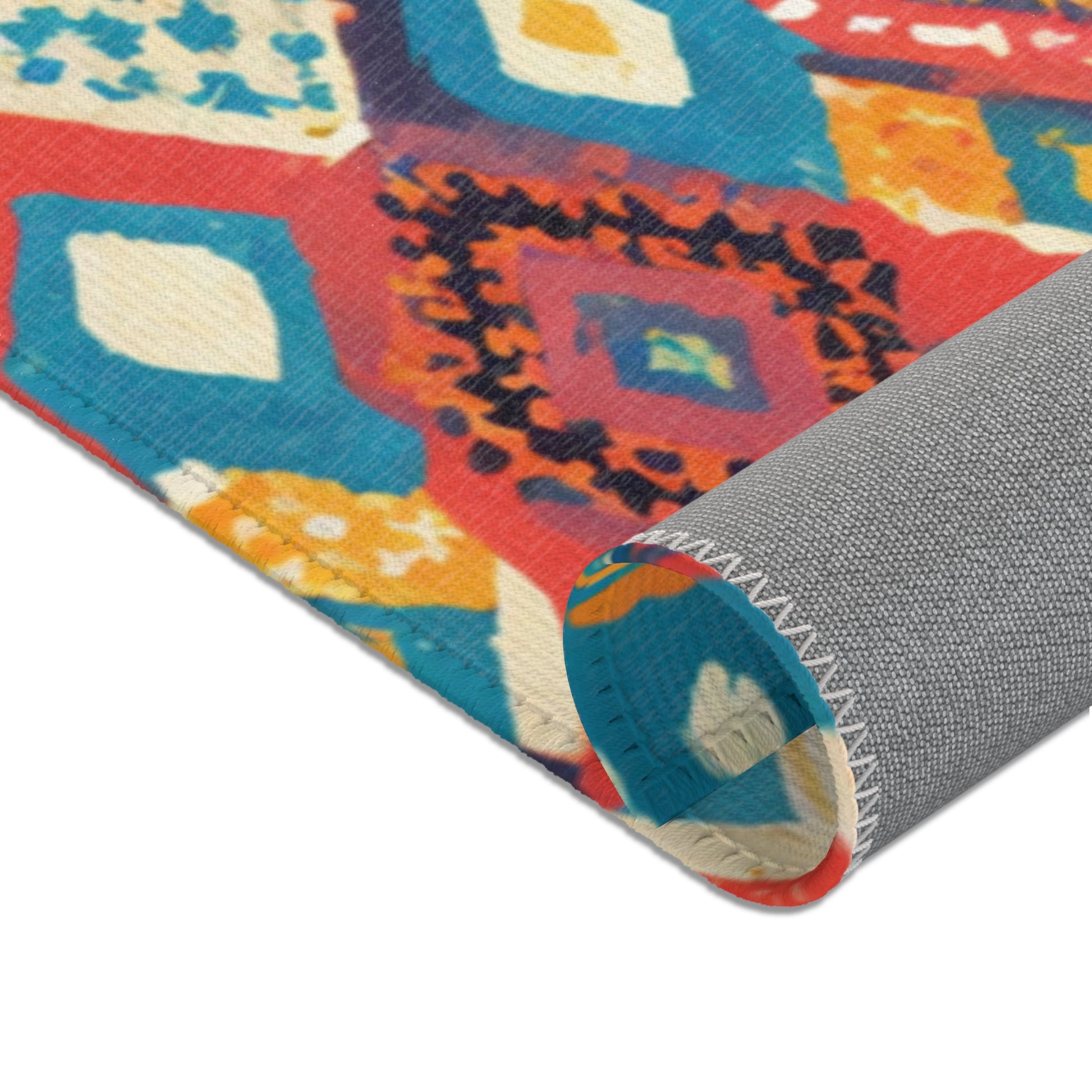 A close-up of a rolled-up rug with colorful, geometric patterns in red, blue, orange, and cream. Perfect for stylish home decor, this durable polyester rug features visible white stitching and a solid gray backing with diamond and floral shapes.