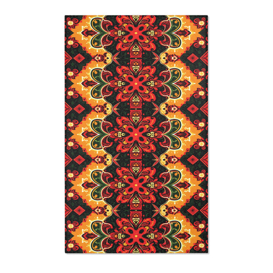 Rectangular fabric featuring a symmetrical floral and geometric pattern in red, yellow, black, and green. Inspired by African design rugs, the bold flower shapes and ornate details make it an eye-catching choice for easy care home decor.