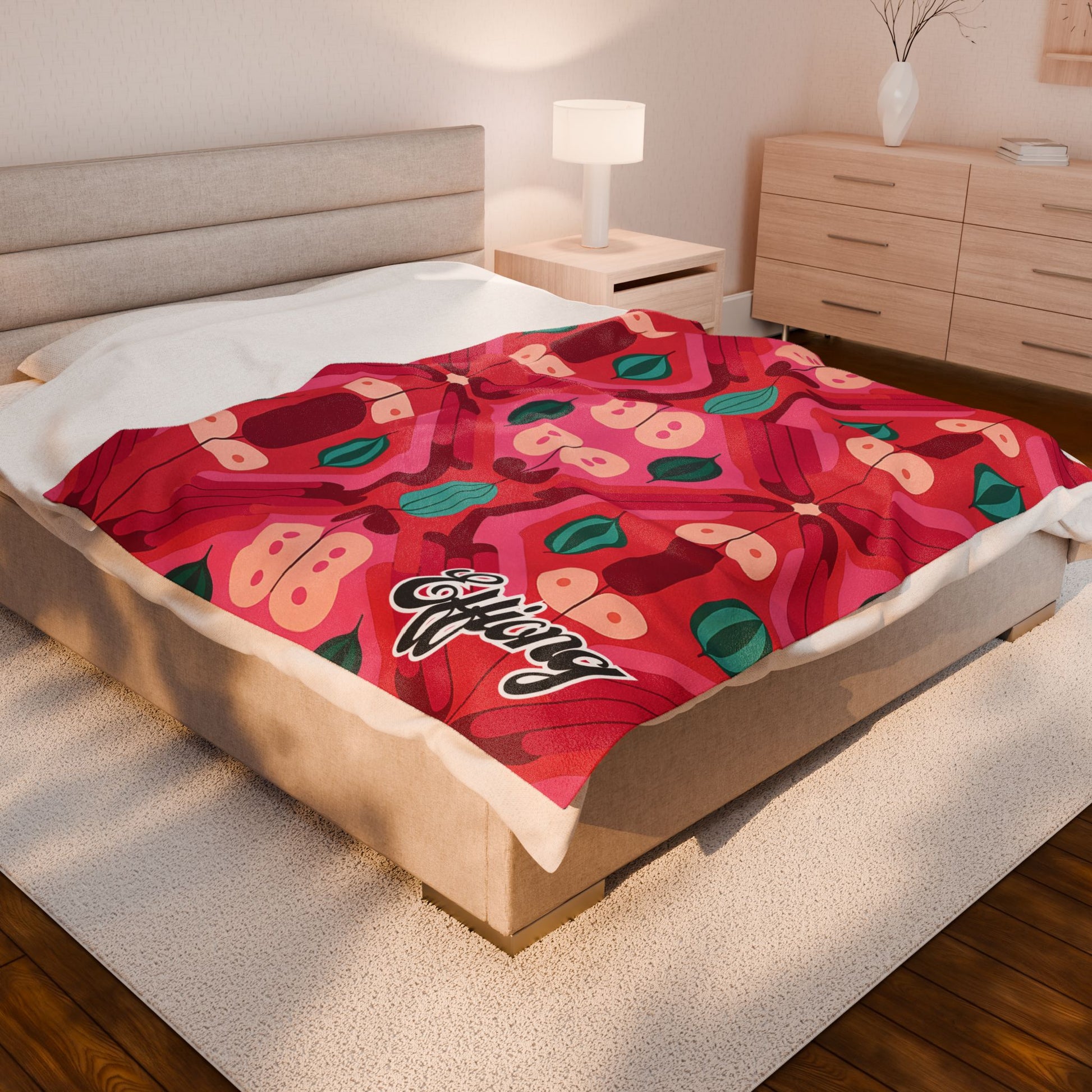 A modern bedroom with a beige bed and light wood furniture features a vibrant, African-inspired blanket with abstract shapes, green accents, and the word Wifey in stylized script—a cozy space perfect for a personalized velveteen blanket custom keepsake gift.
