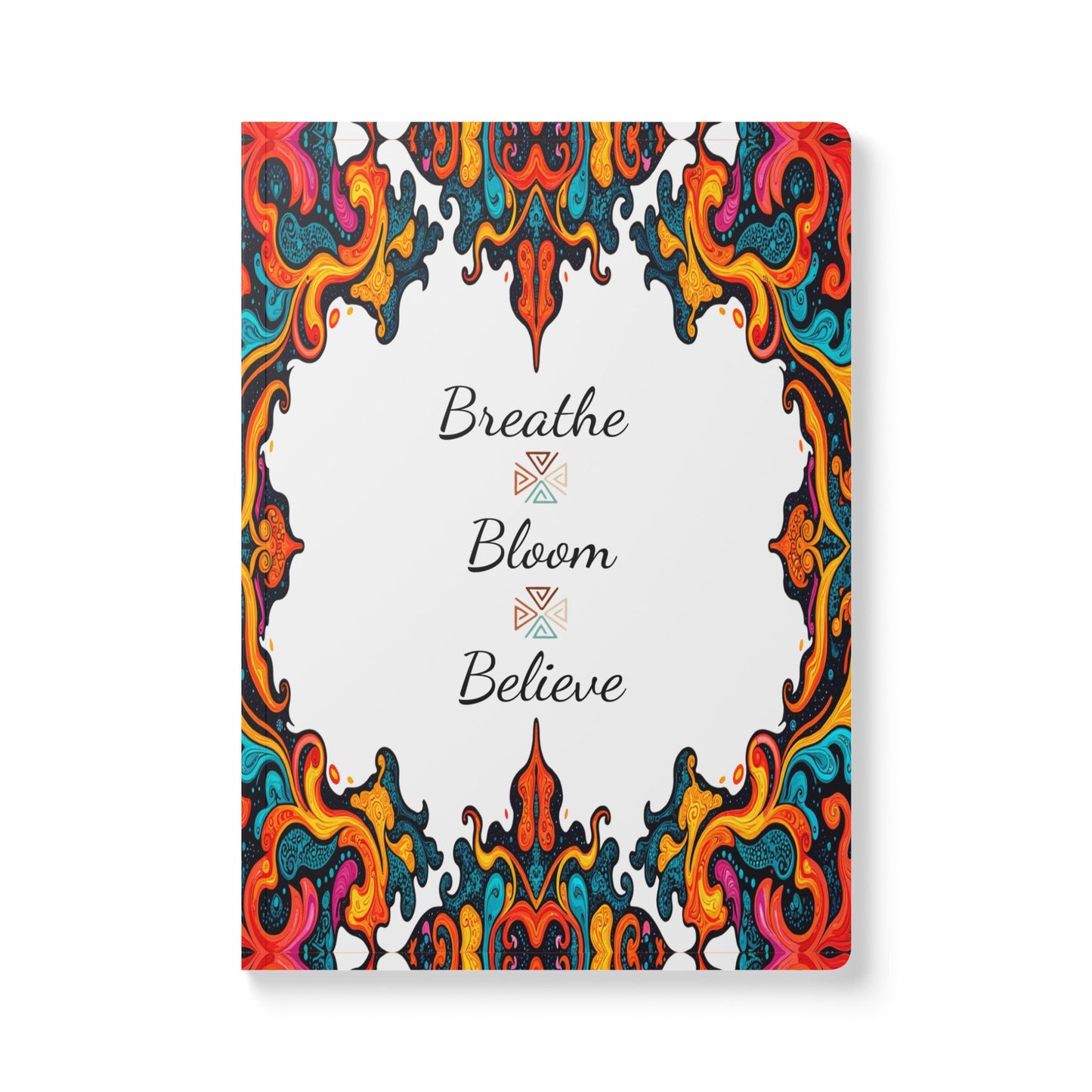 A creative notebook with a white cover featuring swirling, colorful patterns inspired by African designs along the edges. The center reads Breathe Bloom Believe in elegant black script, perfect for daily journaling and self-reflection.