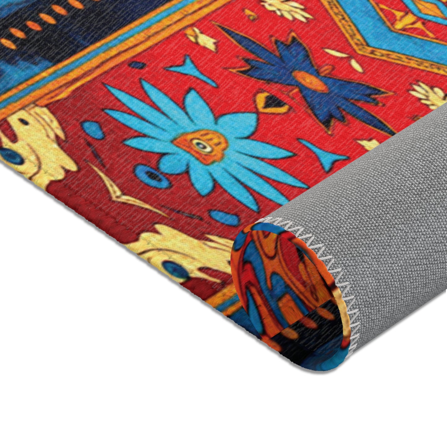 A close-up of a stylish colorful rug, partially rolled up, shows a vibrant pattern with blue flowers, yellow accents, and a red background. The rug’s edge features zigzag stitching, while the underside is solid gray textured fabric.
