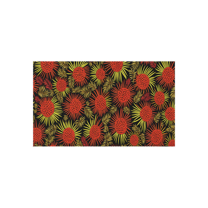 A rectangular, African-inspired pattern featuring red and yellow abstract floral shapes with radiating petals on a black background. The densely packed flowers create a vibrant, dynamic, and colorful design.