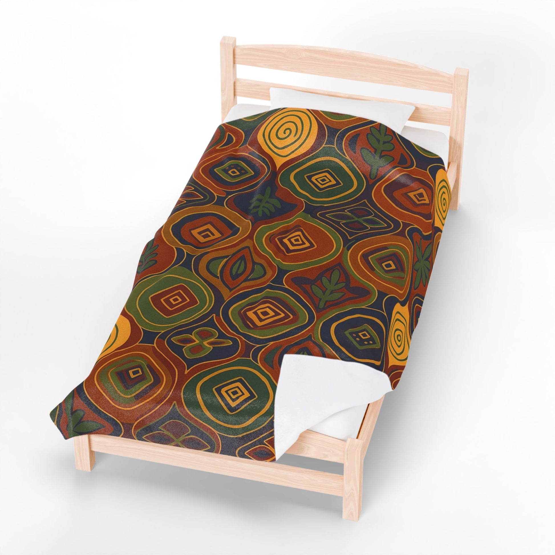 A light wooden single bed with white sheets is topped by an African-inspired blanket, featuring an abstract pattern of earthy-toned geometric shapes, swirls, and leaf motifs in orange, yellow, green, and brown on a dark background.