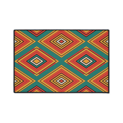 A rectangular mat featuring a bold geometric pattern of concentric diamond shapes in orange, yellow, black, and red on teal, inspired by African-inspired aesthetics. Black borders and a non-slip rubber backing complete the vibrant, symmetrical design.