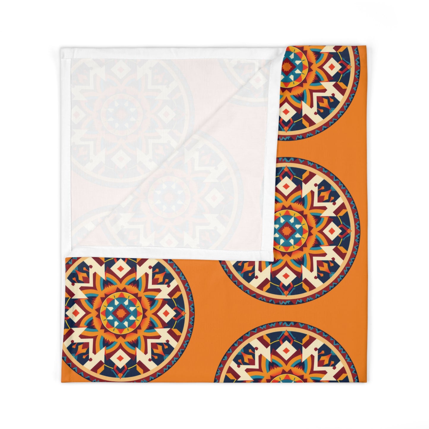 A folded baby swaddle blanket with a bright orange background and large, intricate circular mandala patterns in blue, red, cream, and black; one corner is flipped over to reveal the plain white underside—perfect for African-inspired decor.