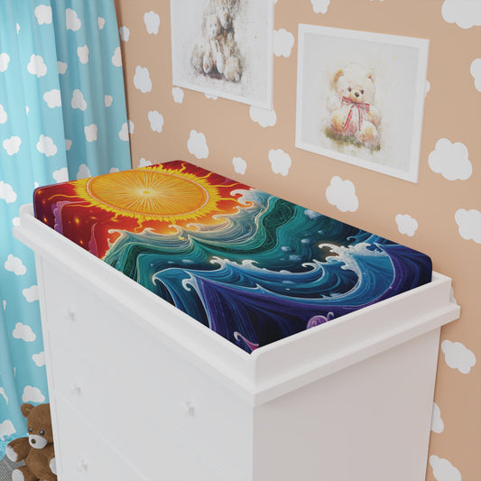 A white changing table with a custom changing pad cover featuring a bright orange sun and swirling blue waves. The nursery boasts light brown walls, African-inspired nursery decor, cloud decals, teddy bear art, and a plush bear on the floor.