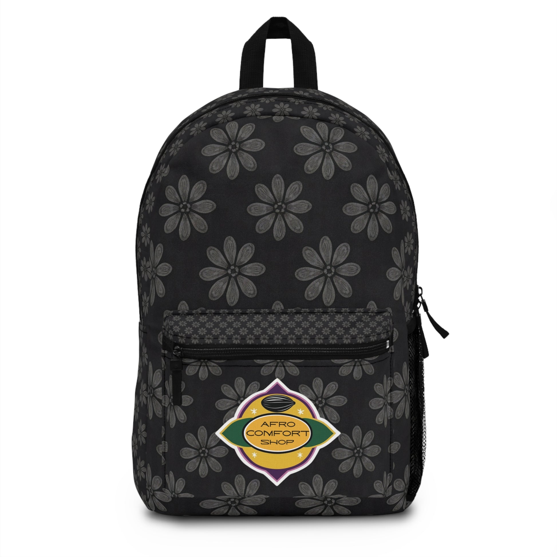 A black, African-inspired backpack with gray floral patterns, a front zip pocket, and a side mesh pocket. The front pocket features a colorful oval patch reading Afro Comfort Shop, echoing the Pan-African flag and celebrating culturally inspired designs.