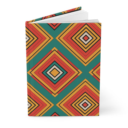 A geometric hardcover notebook with a vibrant tribal pattern journal design, featuring diamond shapes in red, orange, yellow, and black on a teal background. The symmetrical pattern and visible white pages add to its striking appeal.
