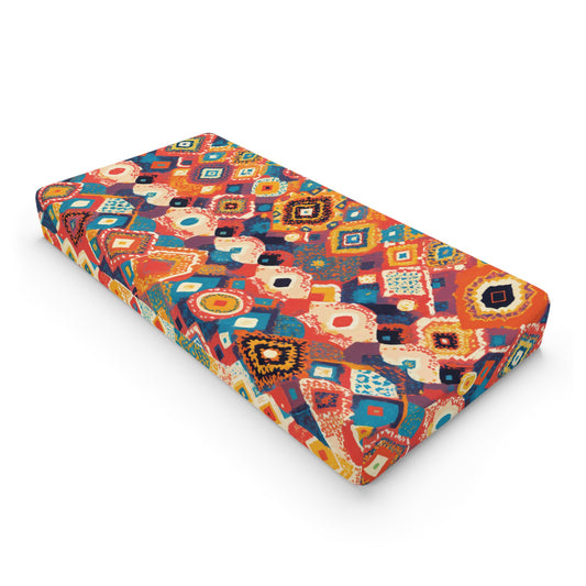 A rectangular mattress with a vibrant, multicolored geometric and abstract pattern in African-inspired designs, featuring shapes like diamonds, squares, and swirls. Displayed against a white background, its perfect for custom changing pad covers.