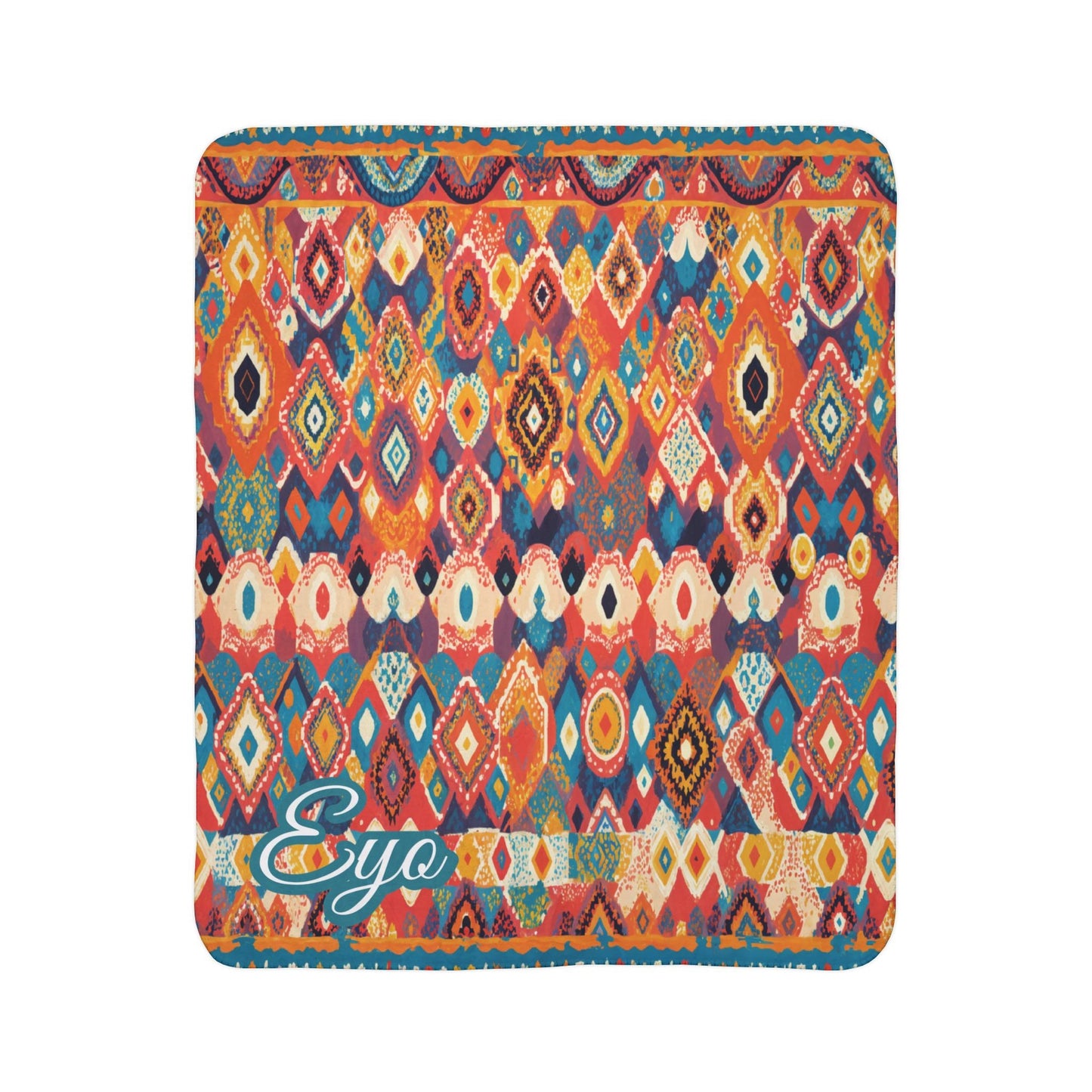 A colorful square blanket features a vibrant, African-inspired geometric pattern of diamonds, ovals, and zigzags in red, orange, blue, and yellow hues. The bottom-left corner displays the word Eyo in teal script with a white outline.