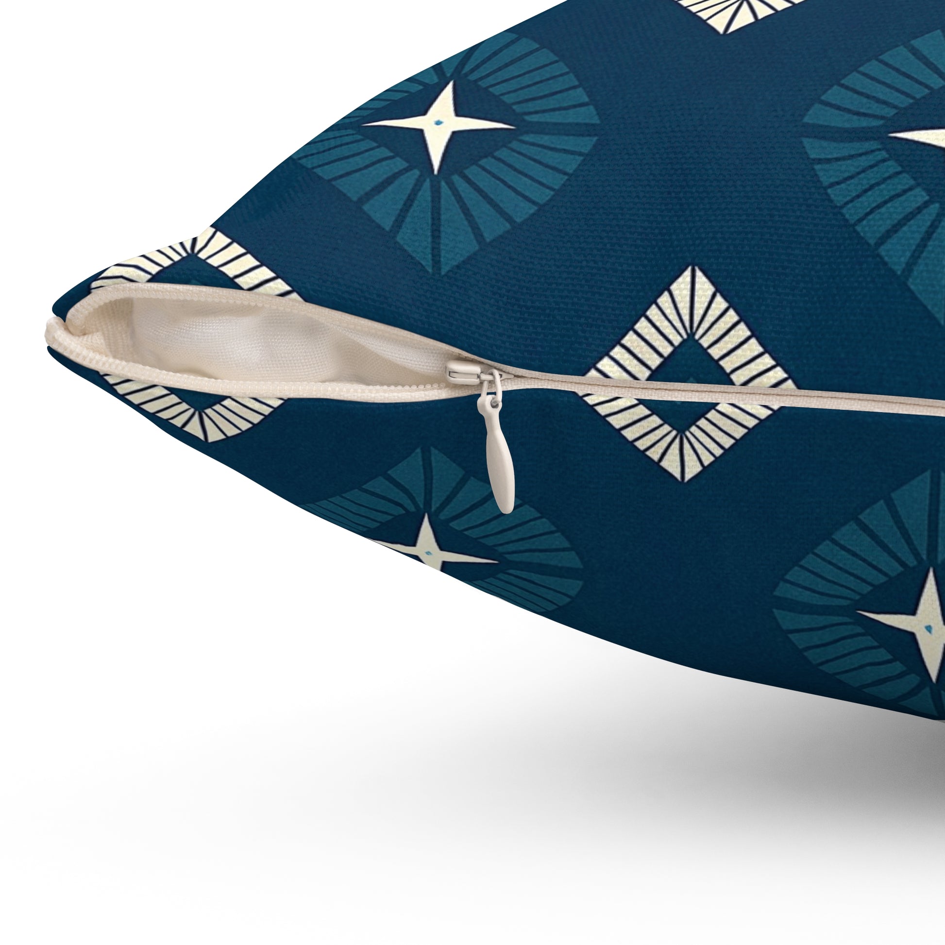 A close-up of a blue African-inspired pillow with a white zipper slightly opened. The fabric features geometric diamond shapes and starburst designs in shades of blue and off-white, perfect for adding unique home decor to your space.