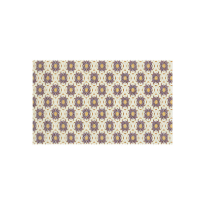 A rectangular pattern features repeating African-inspired circular floral motifs in purple and gold on a cream background. The symmetrical design is evenly spaced, creating a decorative and intricate tiled effect across the entire rectangle.