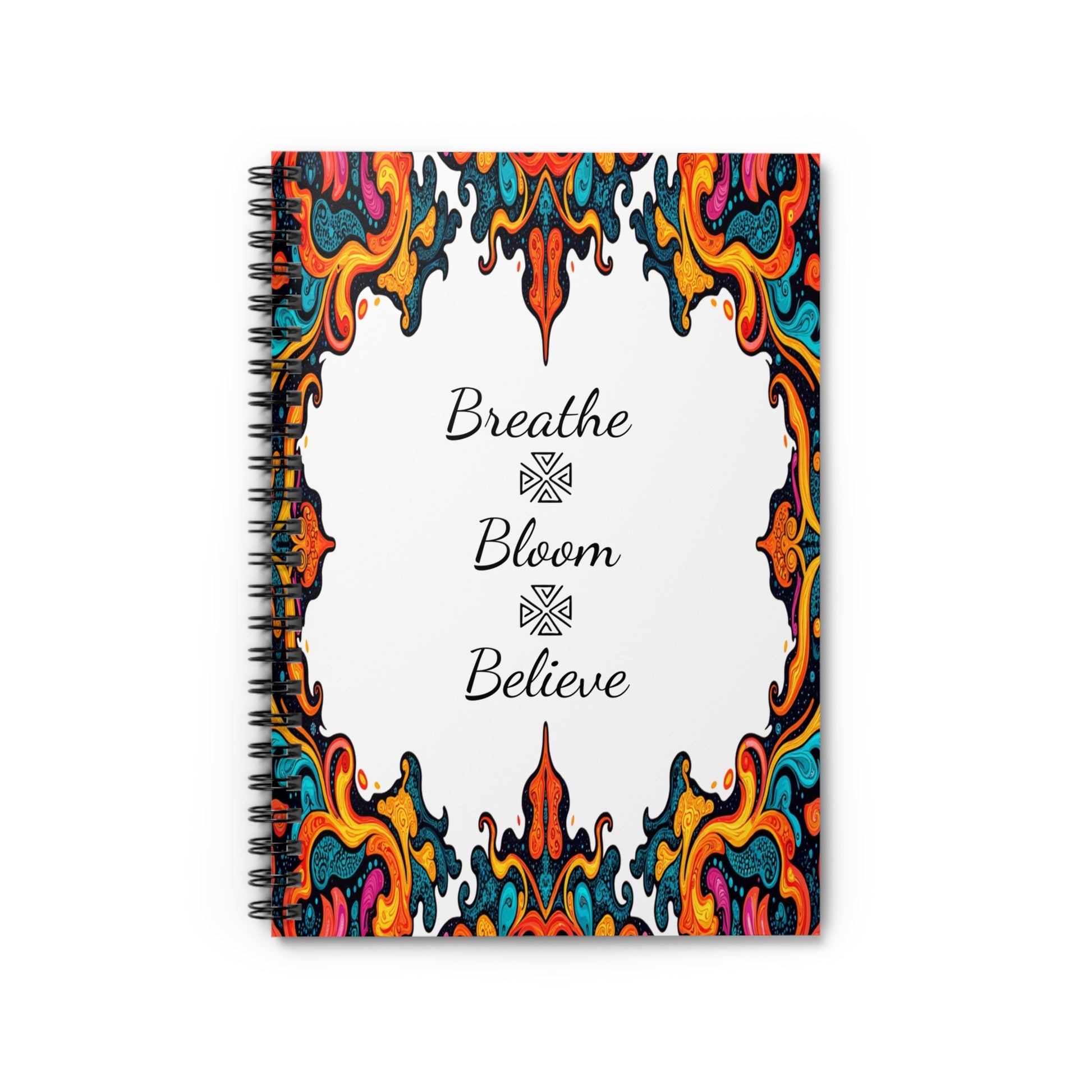 A spiral notebook with an ornate, colorful border featuring culturally inspired designs in red, yellow, orange, teal, and blue. The white center displays cursive black text—“Breathe,” “Bloom,” and “Believe”—each separated by a decorative symbol.