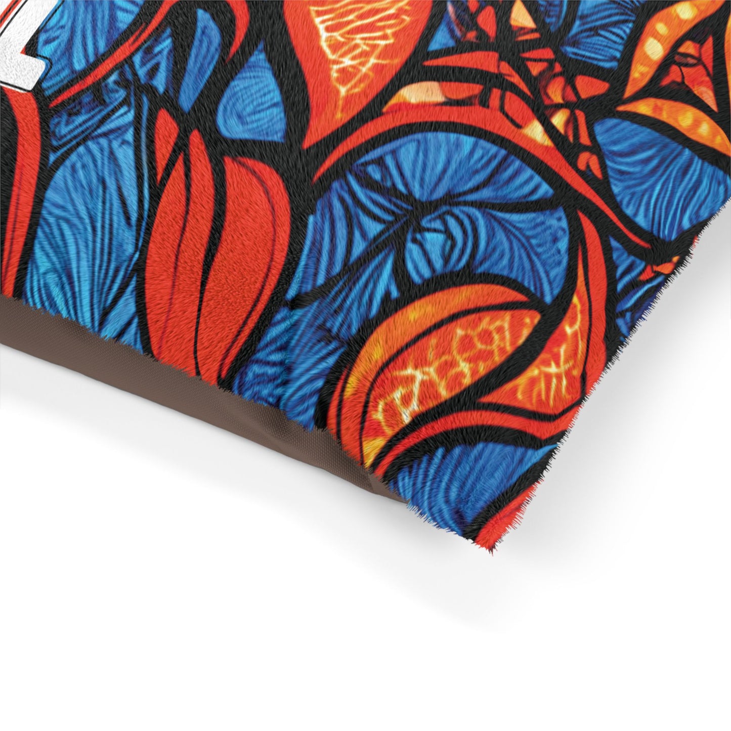 Close-up of a colorful fabric pillow featuring an abstract design with blue, red, orange, and black swirling patterns, resembling leaves or flames—perfect as a stylish pet bed with its soft, textured surface and cozy appeal.