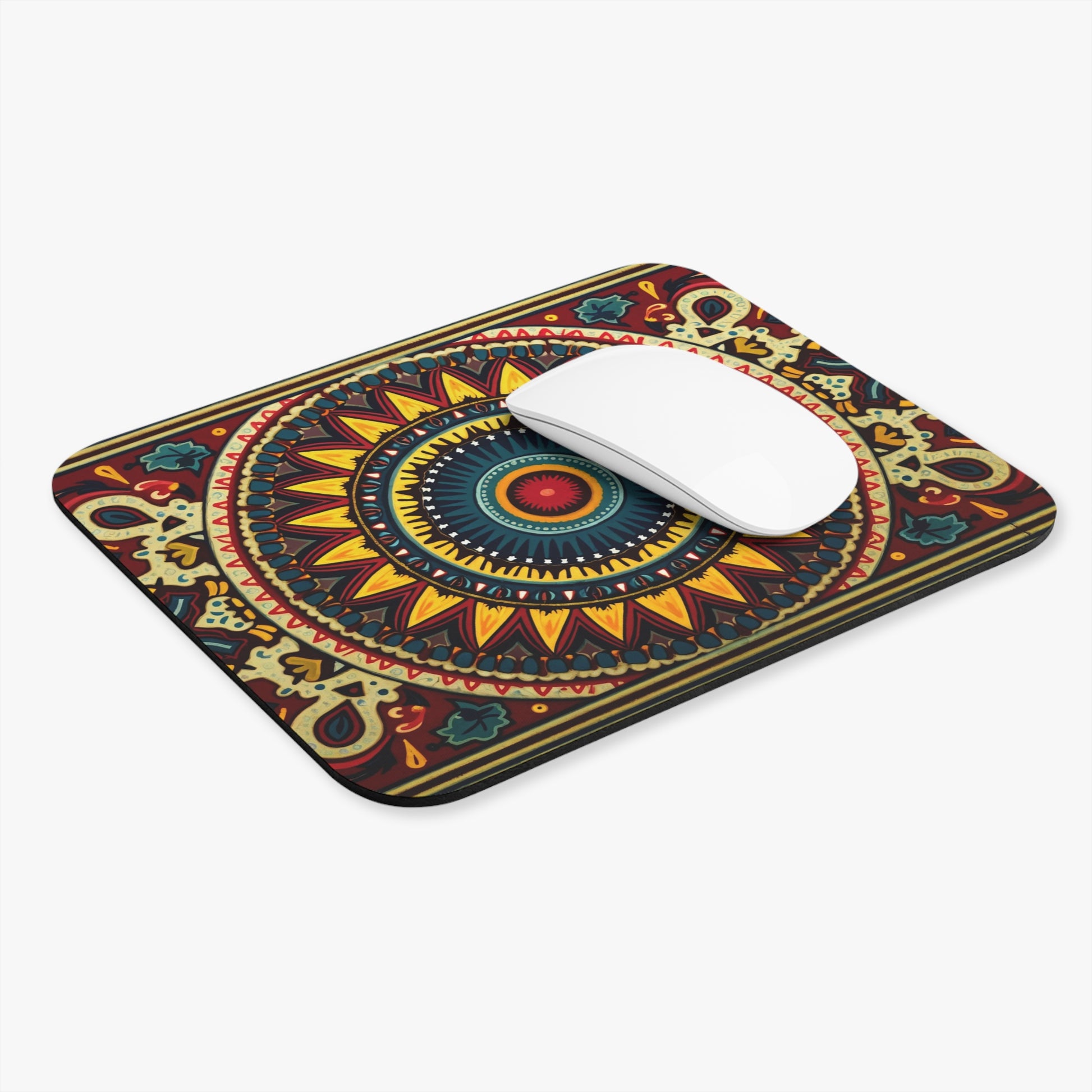 A vibrant desk accessory, this rectangular African-inspired mouse pad showcases intricate mandala patterns in yellow, red, blue, and green. The non-slip rubber base keeps it secure while a white wireless mouse contrasts with the colorful background and rounded corners.