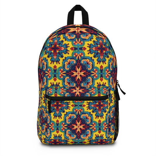 A vibrant travel backpack with a symmetrical, floral pattern in red, blue, green, and gold on yellow. This African-inspired backpack features a front zippered pocket, side mesh pocket, and a sturdy black carrying handle.