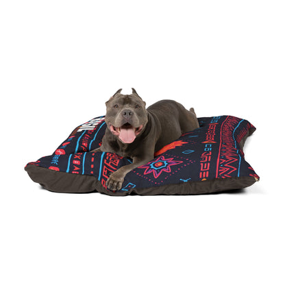 A gray dog with cropped ears and a red collar lies on a large black cushion with colorful, geometric Southwestern patterns. This personalized pet bed offers luxurious comfort, as the happy pup faces forward with its mouth open and tongue out.