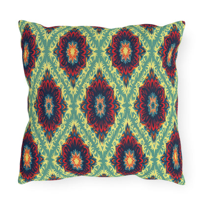 A rectangular pillow with a colorful, symmetrical, African-inspired floral pattern. The design features red, orange, and dark blue flower-like shapes with yellow accents on a light green background, arranged in a repeating diamond layout.
