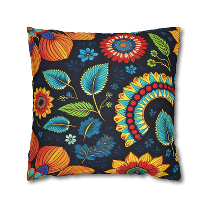A square pillow with a vibrant floral pattern inspired by African pillowcases. Large, colorful flowers and leaves in orange, red, yellow, blue, and green stand out on a dark background, creating a lively and decorative look.