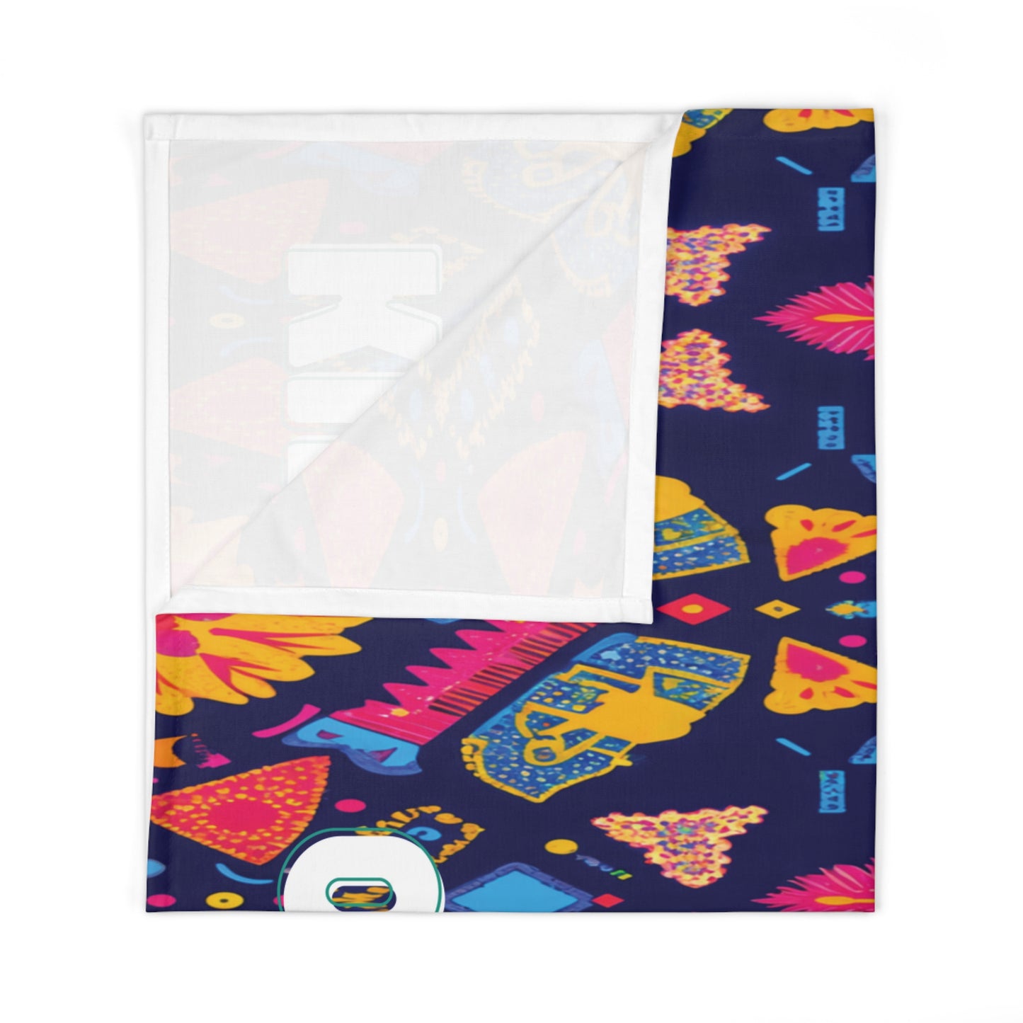 A rectangular swaddle blanket with a colorful pattern on a navy background, featuring stylized skulls, flowers, and geometric shapes in pink, yellow, blue, and orange. A corner is folded to reveal its white underside. A small round logo appears near the bottom edge.
