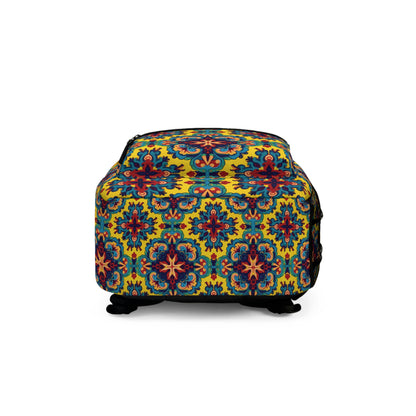 A rectangular ottoman with a vibrant, colorful pattern reminiscent of a boho chic rucksack, featuring symmetrical floral and geometric motifs in blue, red, and orange on a yellow background. The ottoman has short black legs and a smooth upholstered surface.