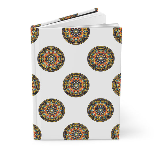 A hardcover journal with a white cover featuring a repeating pattern of intricate, colorful circular mandalas in orange, blue, yellow, and black. The book is slightly open and stands against a plain white background.