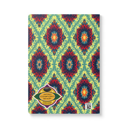 A creative notebook with a vibrant geometric pattern in red, blue, and yellow on a green background. A yellow label with “AFRO COMFORT SHOP” and a QR code are on the bottom left corner of this African-inspired journal.