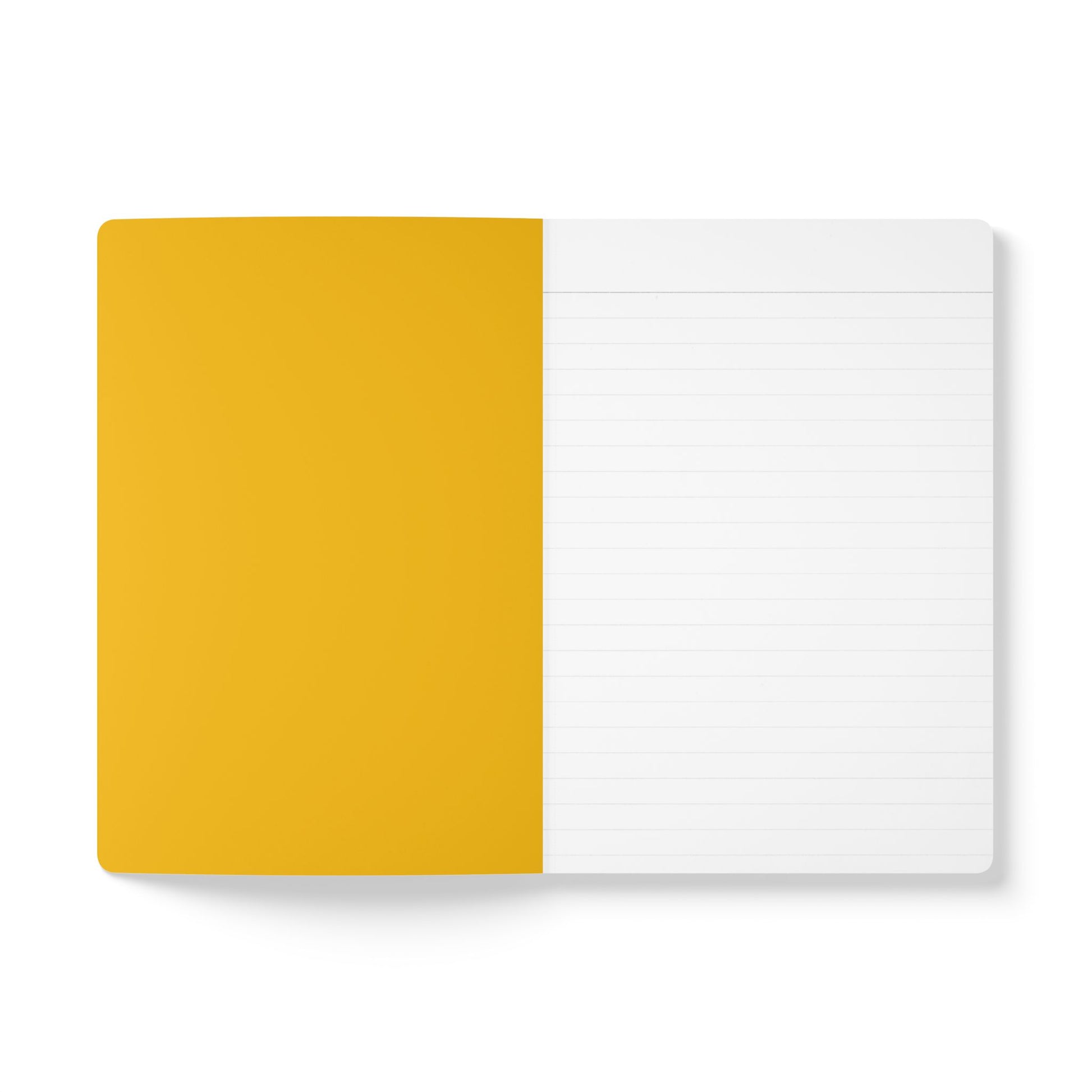 An open notebook on a white surface, ideal for creative journaling. The left page is solid mustard yellow, while the right page is white with light gray horizontal lines for writing. The notebook cover is not visible, and the lighting is bright and even.