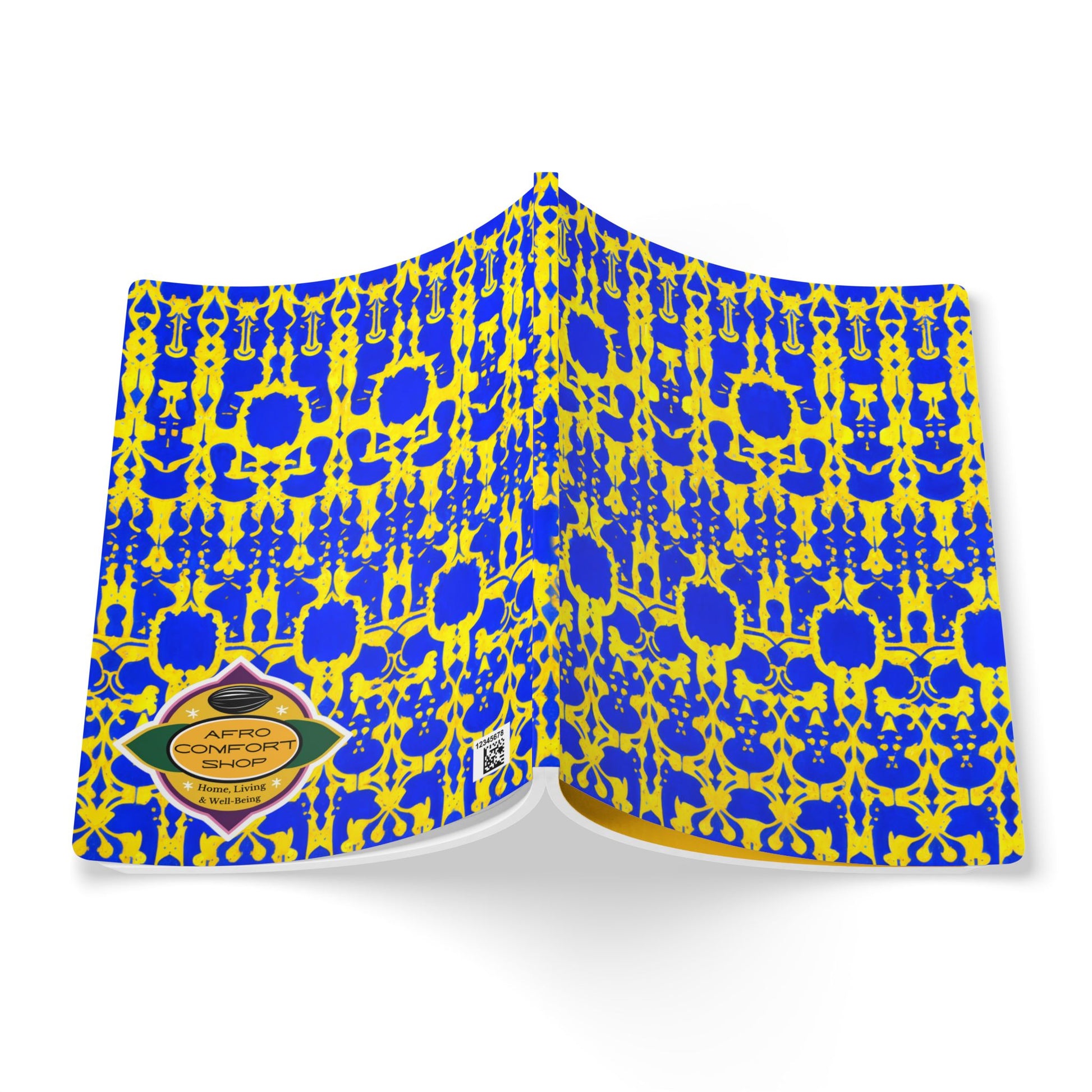 An open book with a vibrant cover featuring an intricate blue and yellow geometric pattern, inspired by African-inspired journal designs. A gold and black label on the bottom left reads SAFFRON COMFORT SHOW. The inside cover and pages are visible on a white background.