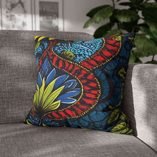 A decorative throw pillow with bold, African-inspired patterns in red, blue, yellow, and black rests on a light gray sofa. Leafy green plants and framed wall art complete this vibrant, well-lit living room setting.