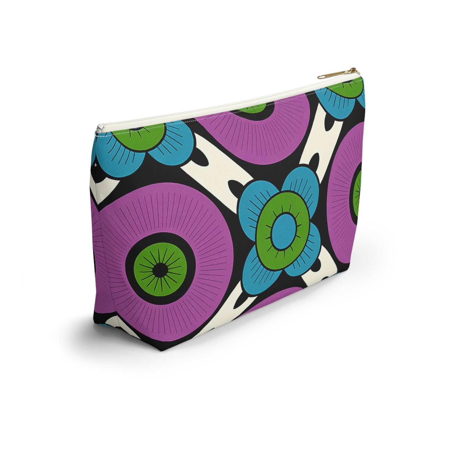 A zippered cosmetic travel bag with a bold, retro floral design and subtle African-inspired patterns. Large purple and blue flowers with green centers pop on a black and white background. The T-bottom pouch stands upright, photographed on a white surface.