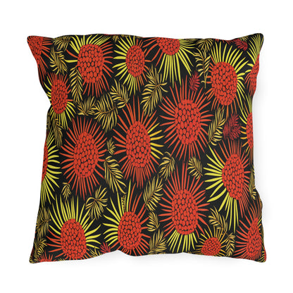 A rectangular pillow with a black background features a bold, African-inspired pattern of red and orange pinecone-like shapes and yellow radiating lines, accented by leafy green fronds for a vibrant, tropical design.