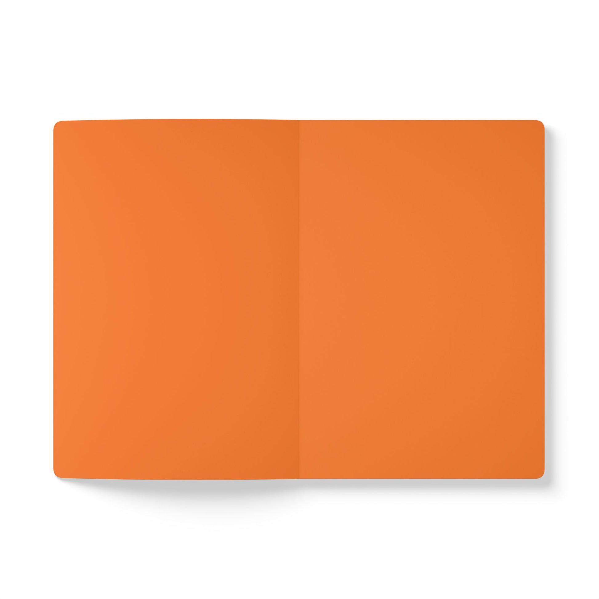 An open creative journal with two blank orange pages lies flat on a white surface. The vertical crease divides the pages evenly, while a subtle shadow appears along the left edge. The image is minimalistic and well-lit.