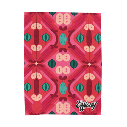 A rectangular personalized velveteen blanket features a bold, symmetrical, retro-style geometric pattern in pink, red, teal, and green. The name “Effiong” appears in white cursive on a solid raspberry background—perfect as a custom gift.