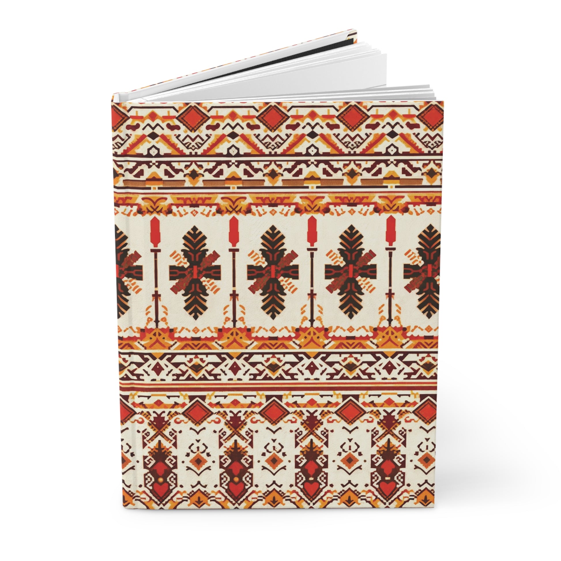 A hardcover journal featuring intricate, symmetrical folk-inspired patterns in red, orange, black, and yellow tones. The African-inspired design includes geometric shapes, crosses, stylized leaves, and repeating horizontal bands on a cream background.