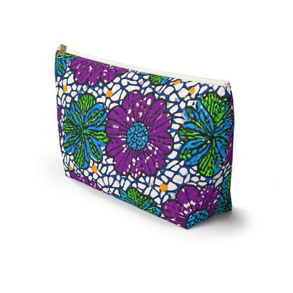 A T-bottom pouch featuring a bold, colorful floral pattern with large purple and blue flowers, green leaves, and small yellow accents on a white background with a blue lace-like design—perfect as a cosmetic travel bag inspired by African-inspired patterns.