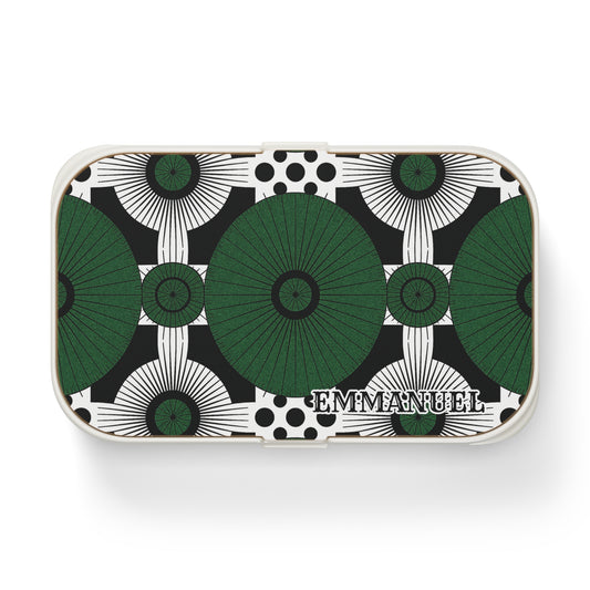 Rectangular custom lunch box with a geometric pattern of large green and black circular shapes and black dots on a white background. The bold, symmetrical design is personalized with EMMANUEL in serif letters in the lower right corner.