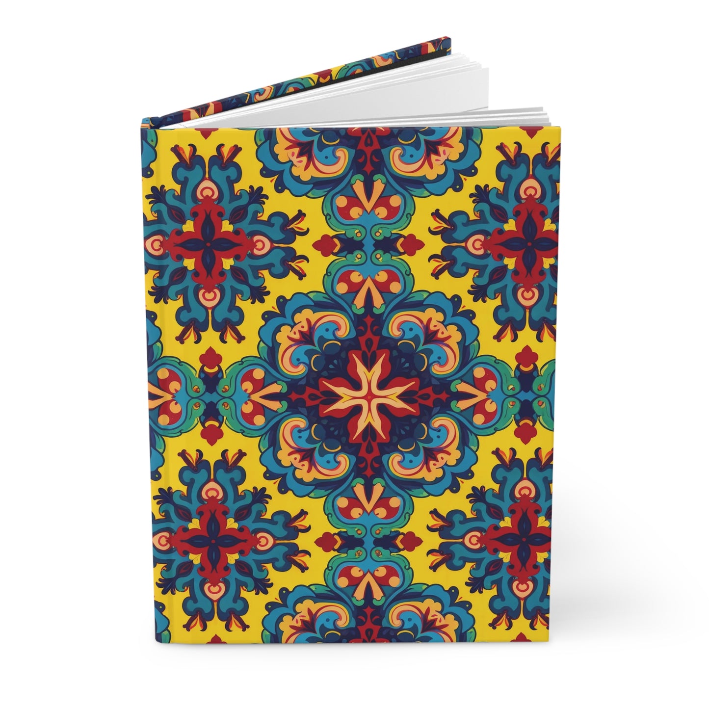 A hardcover African-inspired journal stands upright, featuring a vibrant, symmetrical floral pattern in red, blue, orange, and teal on a bright yellow background. The book is partially open, revealing white pages inside. The pattern repeats seamlessly across the cover and spine.