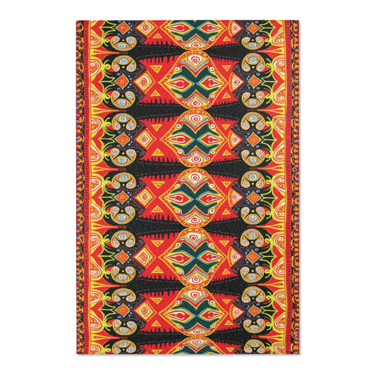 A vibrant, symmetrical textile inspired by African design rugs, featuring bold red, black, yellow, and green geometric and abstract patterns. Concentric circles, triangles, and wavy lines create a stylish kaleidoscopic effect with repeating border details.