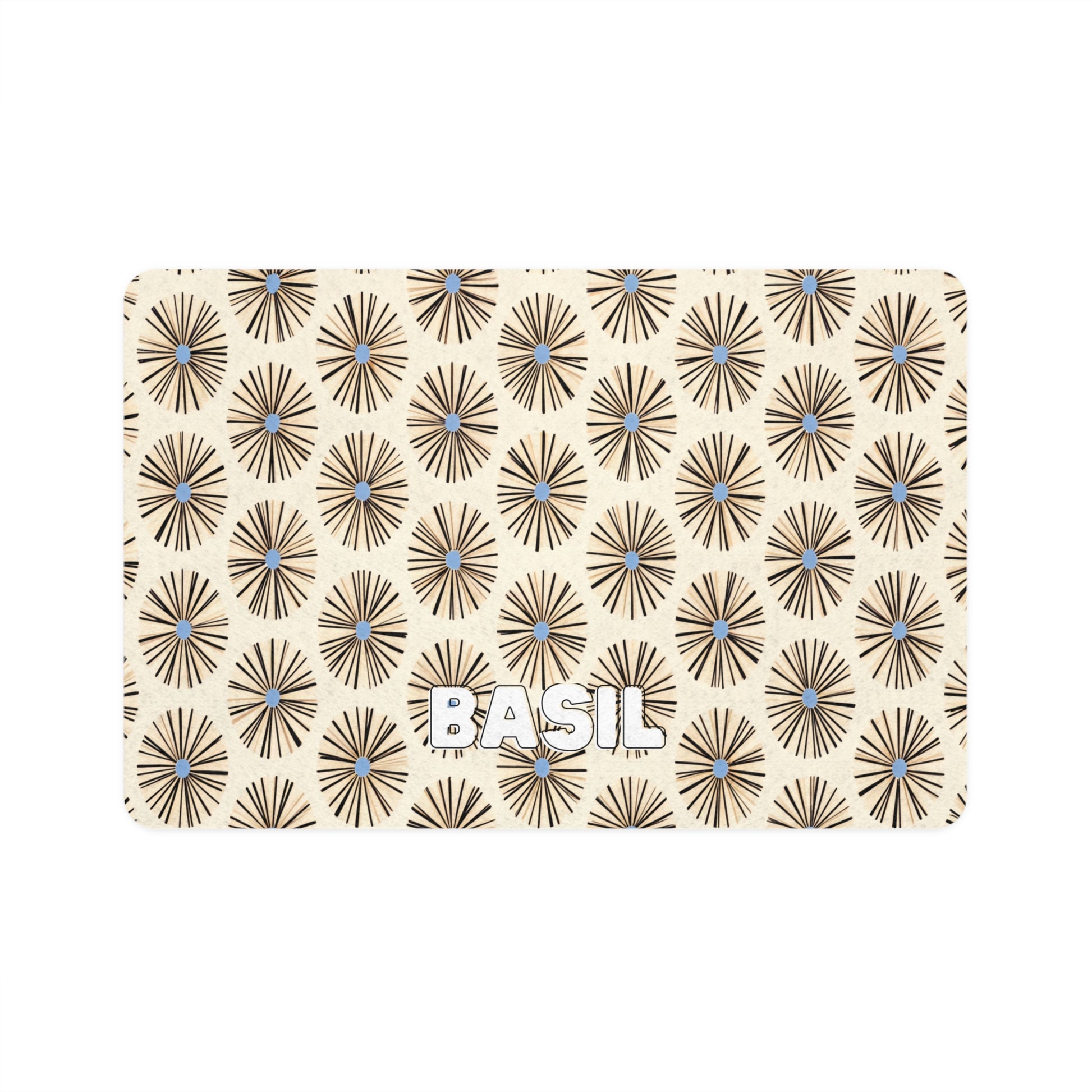 A beige card with repeating brown geometric sunburst patterns featuring small blue centers. The African-inspired design highlights the word BASIL in bold white uppercase letters near the bottom center of the card.