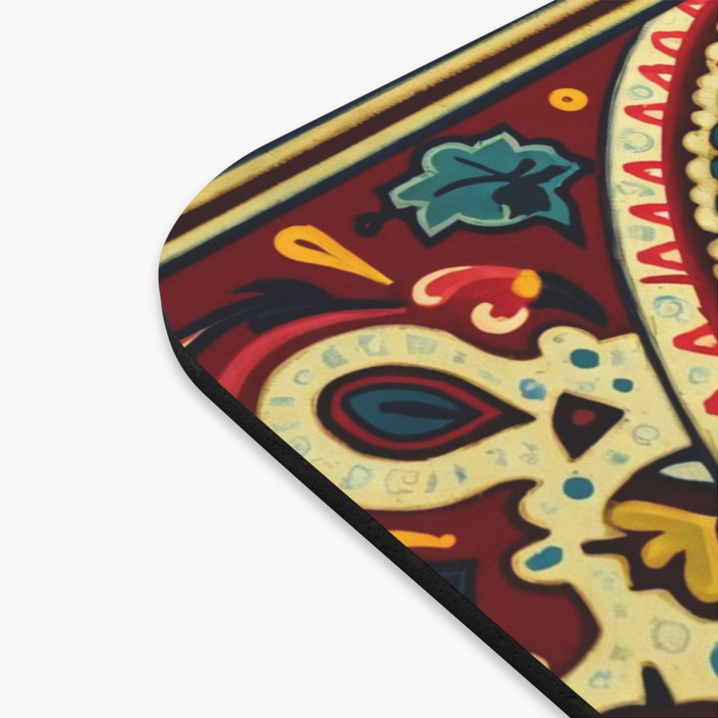 Close-up of an African-inspired mouse pad corner with a vibrant, intricate floral and paisley pattern in red, yellow, blue, and green. Rounded edges, a non-slip rubber base, and detailed decorative motifs enrich this vibrant desk accessory.