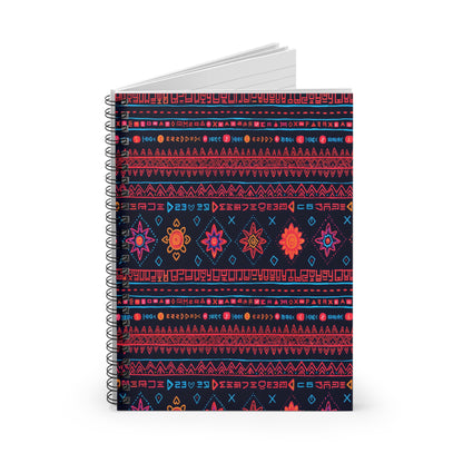 A spiral-bound, African-inspired spiral notebook with a dark cover featuring vibrant, geometric folk patterns in red, orange, pink, and blue. Rows of abstract symbols, diamond shapes, and floral motifs adorn this premium writing notebook with lined pages inside.