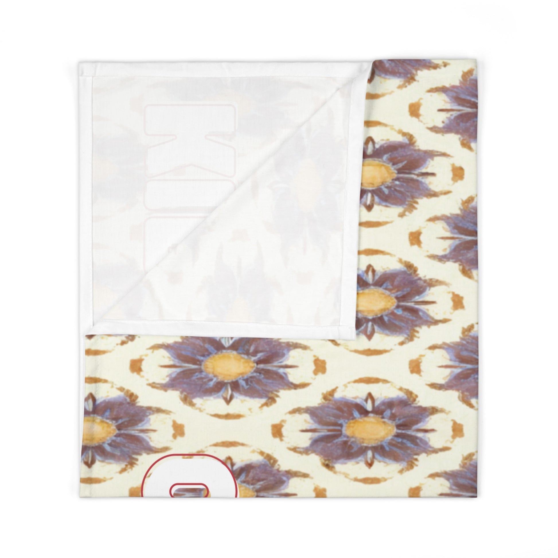 A square baby swaddle blanket with a folded corner, featuring a repeating pattern of purple and yellow abstract flowers on cream. The lower left corner reveals part of a red-outline number, partially visible under the fold—perfect for African-inspired decor.