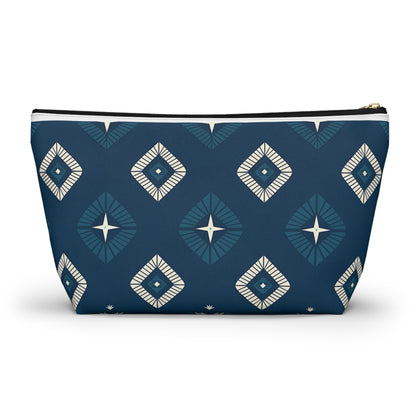 A zippered T-bottom pouch stands upright, featuring a dark blue background with African-inspired patterns—repeating geometric diamond shapes in lighter blue and cream, each with a star-like center for a modern, symmetrical cosmetic travel bag design.