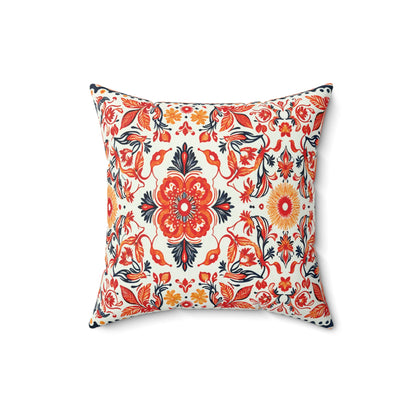 Square decorative throw pillow with a vibrant floral and foliate pattern in red, orange, yellow, and navy blue on white. The symmetrical design features large central flowers and leafy vines, creating a bold African accent pillow for any space.