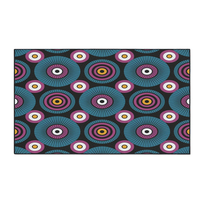 A bold, African-inspired geometric pattern features concentric circles in teal, purple, pink, yellow, and white on a black background. Radial lines and alternating rings create a rhythmic effect—perfect for custom floor mats with a non-slip surface.